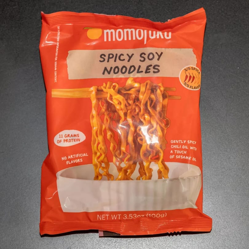 Momojuku Spicy Soy Noodles package, featuring an illustration of noodles held by chopsticks over a bowl.